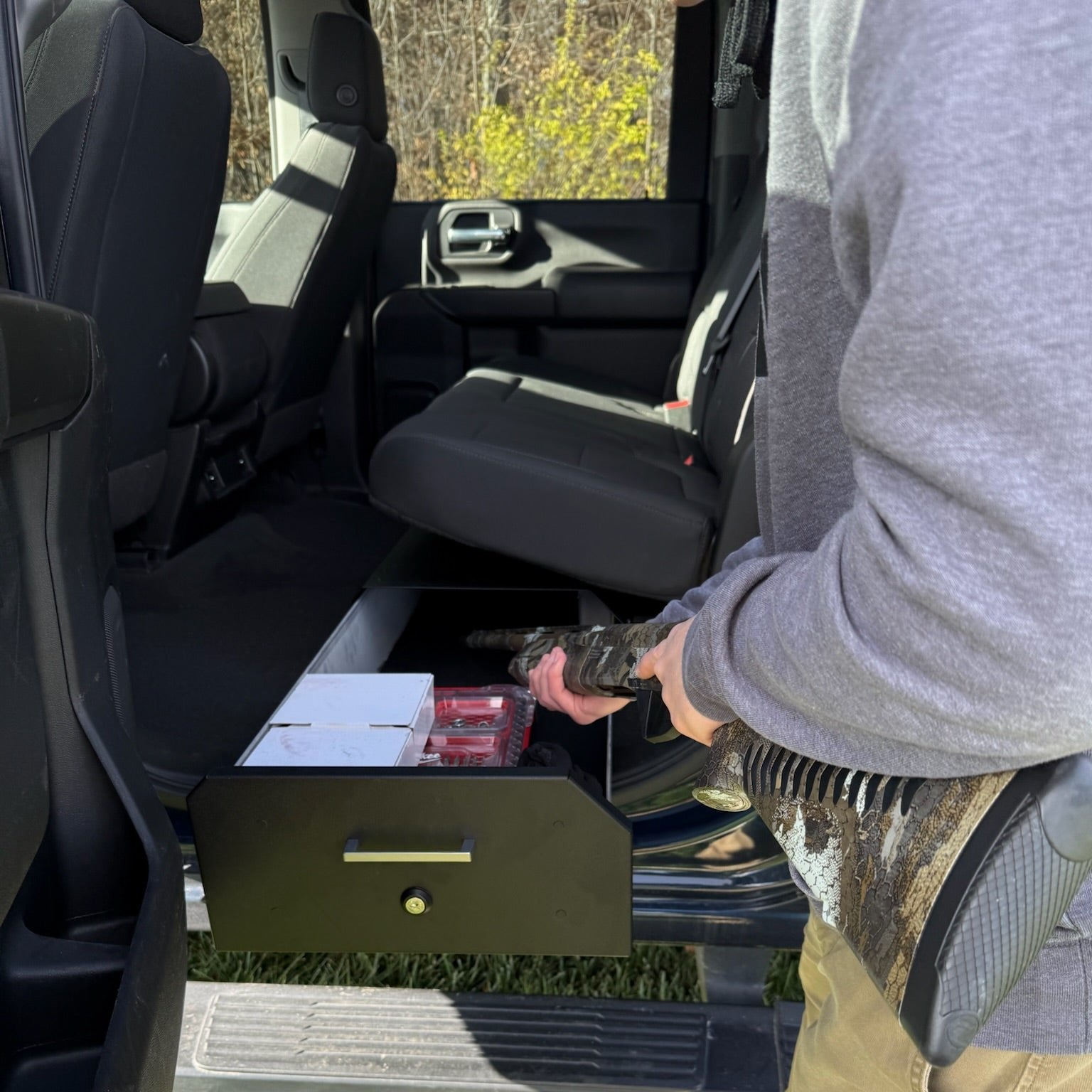 Ram Gear-Guard Under-Seat Locker with the door open with the carpet option showing how it can be used.  The locker is a high-quality powder coated galvanealed steel.